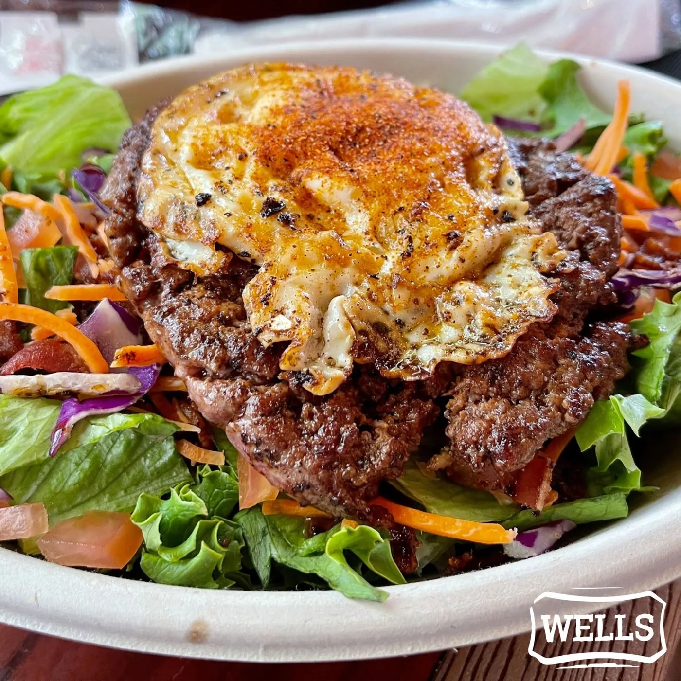 The Grazer salad — greens, carrots and cabbage under a beef patty and a fried egg