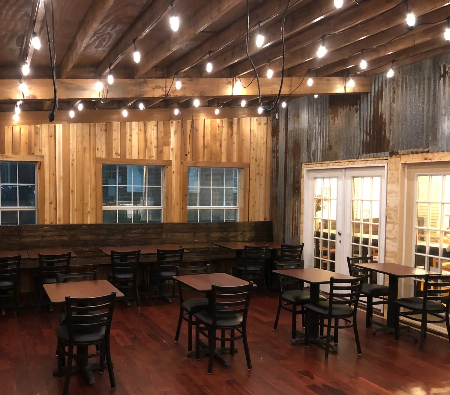 The finished back room — cedar walls, string lights and tables ready for a full house