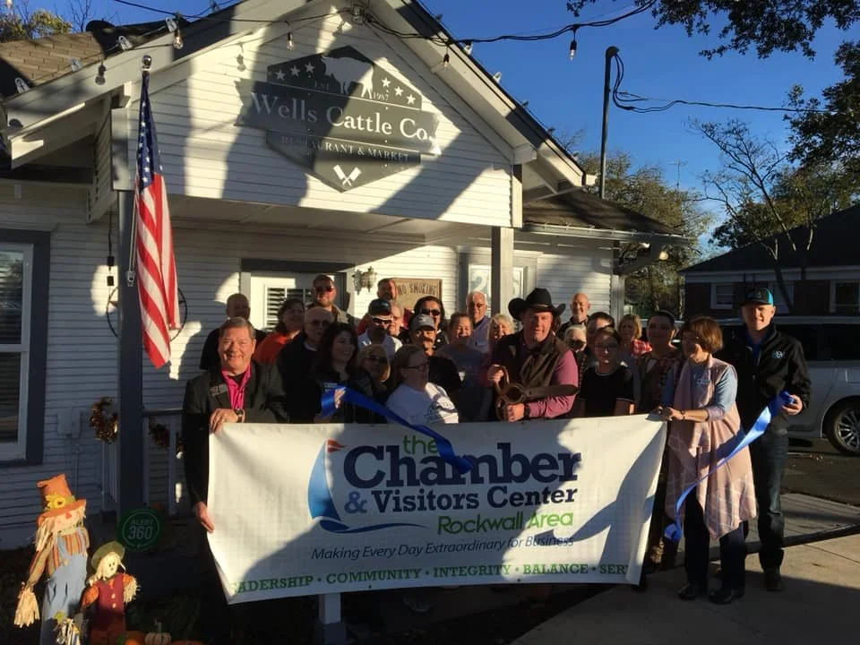 Ribbon cutting with the Rockwall Chamber outside the house